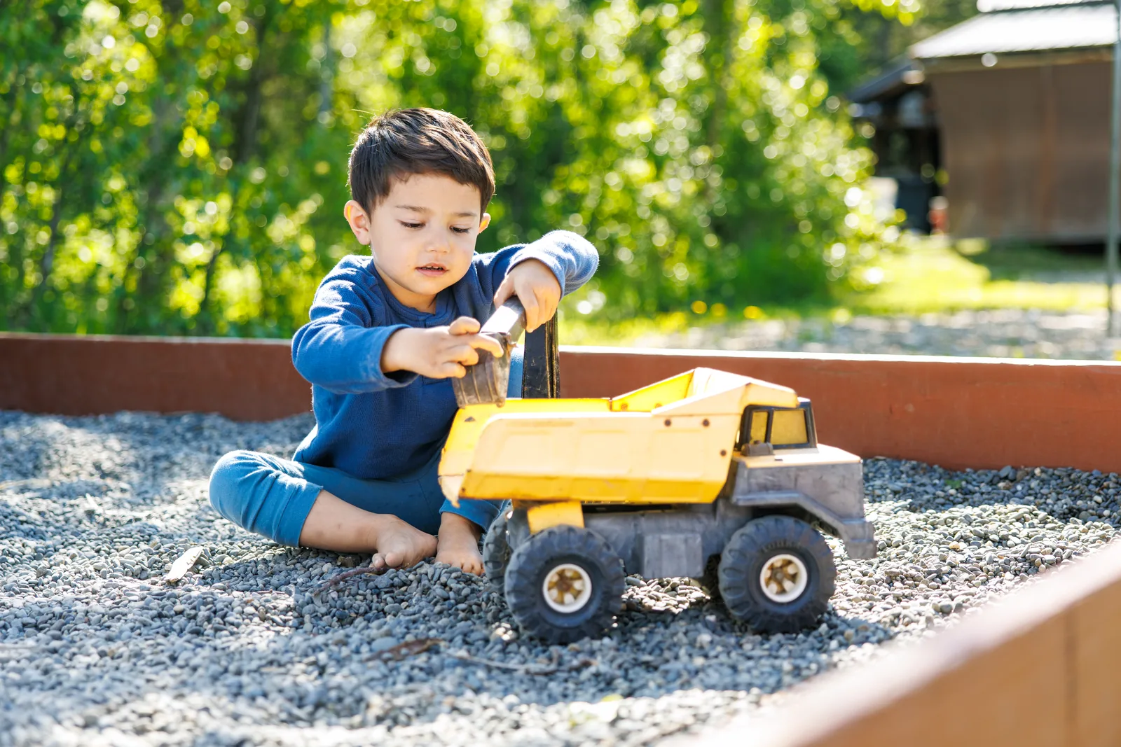Child playing with a toy truck in the resort sandbox